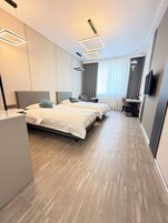 Una habitación de hotel con una cama grande, un escritorio, una silla y un televisor.