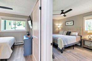 Ein Schlafzimmer mit Bett, Nachttisch, Lampe und Deckenventilator.
