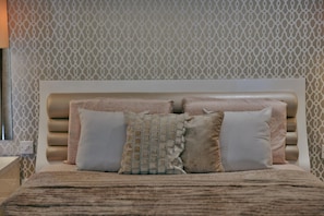 A bed with a headboard, a patterned wall, and a power outlet. - Luxury Duplex With Jacuzzi, Stunning Views (St. Julian's)