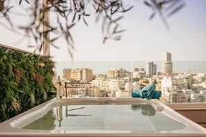 A spa area with a hot tub, a towel, and a cityscape view. - Luxury Duplex With Jacuzzi, Stunning Views (St. Julian's)