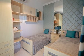 A bedroom with two beds, a wardrobe, a mirror, and a bedside table. - Luxury Duplex With Jacuzzi, Stunning Views (St. Julian's)