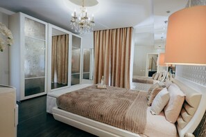A bedroom with a large bed, a chandelier, and a wardrobe with frosted glass doors. - Luxury Duplex With Jacuzzi, Stunning Views (St. Julian's)