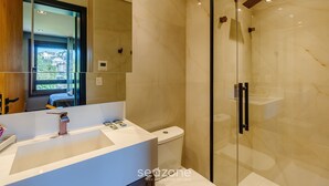 A modern bathroom with a glass shower enclosure, a white sink with a contemporary faucet, and a toilet. - Beautiful Apartment in Gramado Dms0304 (Gramado)