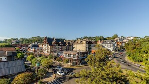 A residential area with multiple-story houses, a main road, and parked cars. - Beautiful Apartment in Gramado Dms0304 (Gramado)