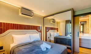Ein Hotelzimmer mit zwei Betten, einem großen Spiegel und einer Klimaanlage.