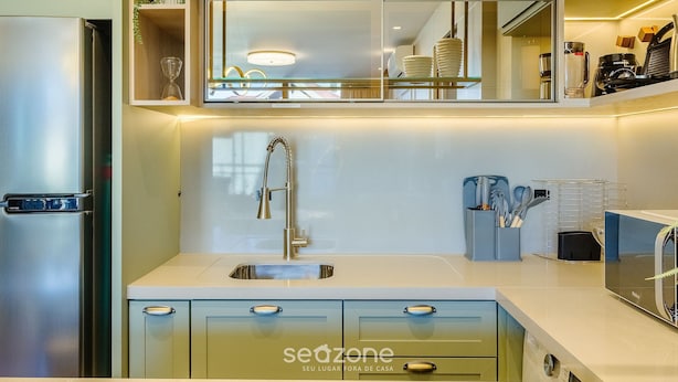 A modern kitchen with a stainless steel refrigerator, a built-in sink, and a microwave. - Apt w/ Balcony, Fireplace & View in Center Dms0107 (Gramado)