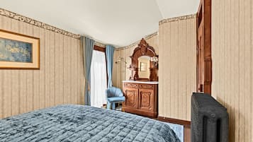 Ein Hotelzimmer mit Bett, Schminktisch, Stuhl und Spiegel.