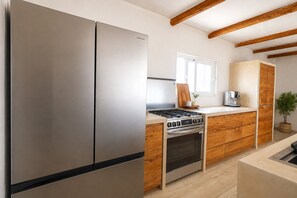 Eine moderne Küche mit Edelstahlgeräten, Holzschränken und einem eingebauten Backofen.