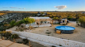 Ein Haus mit Pool, umgeben von einer Steinmauer und Wüstenpflanzen.