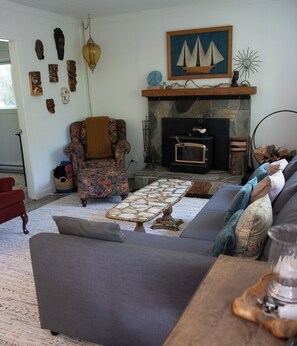 A living room with a fireplace, a patterned armchair, a sofa, and a coffee table.