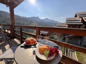 A table with food and drinks on a balcony overlooking a mountainous landscape. - 50m from ski slopes, 4th floor, swimming pool, balcony, ski locker, 50m², Vars (Vars)