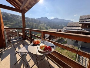 A balcony with a table set for two, overlooking a mountainous landscape. - 50m from ski slopes, 4th floor, swimming pool, balcony, ski locker, 50m², Vars (Vars)