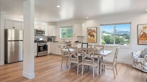 A modern kitchen with stainless steel appliances, a dining area with wooden chairs, and large windows offering a view of the outdoors. - Stampede Loft at The 8 Mile by Avantstay Private Porch + Full Kitchen Ranch Acreage + Trails (Santa Margarita)