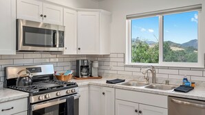 A modern kitchen with stainless steel appliances, a gas stove, a kettle, and a coffee maker. - Stampede Loft at The 8 Mile by Avantstay Private Porch + Full Kitchen Ranch Acreage + Trails (Santa Margarita)