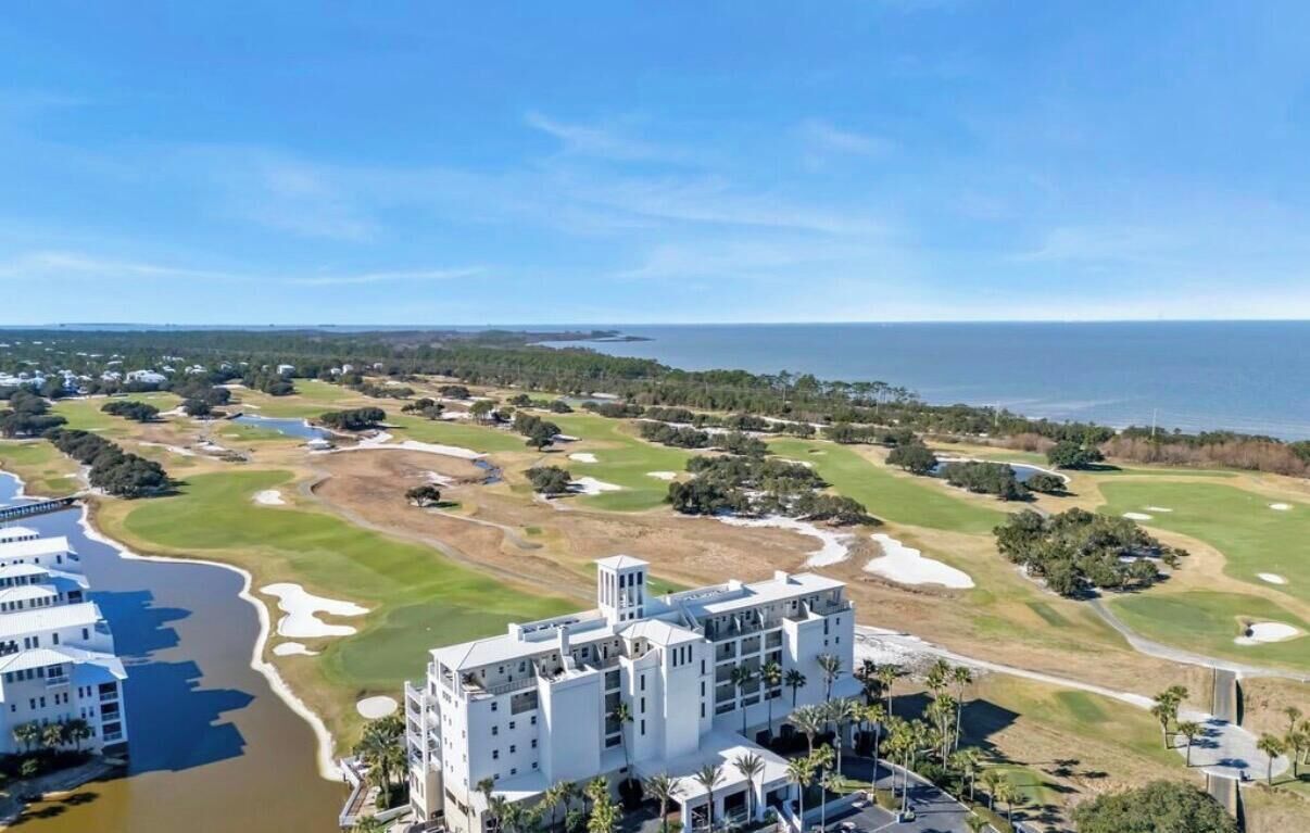 Ein Küsten-Golfplatz mit einem großen Gebäude direkt am Wasser.
