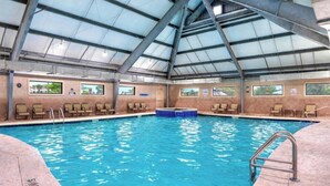 An indoor swimming pool with a high ceiling and multiple windows. - Beachfront Getaway w/ Pools, Sauna & Ocean Views (Gulf Shores)