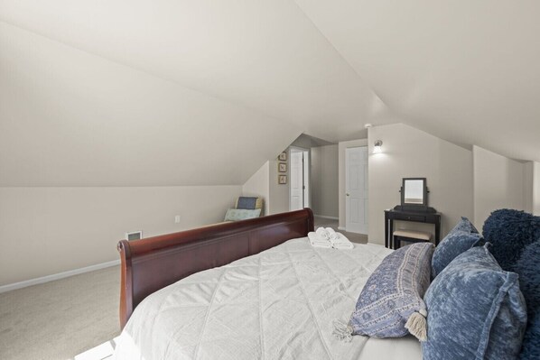 Une chambre avec un grand lit, un bureau et une chaise.