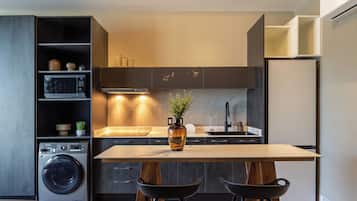 A modern kitchen with a central island, built-in appliances, and a seating area with stools.