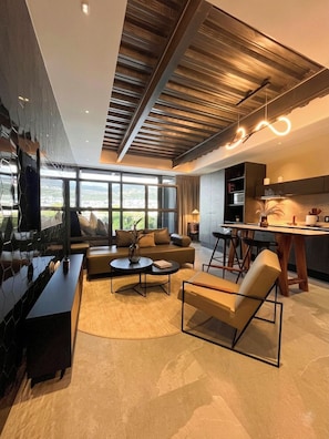 A modern living room with a sofa, coffee table, and bar stools.