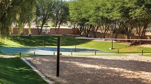 A basketball court with a net, surrounded by sand, trees, and a fence. - Coachella2ndWeek: Cozy 1-bedroom, 2 bed condo in Palm Desert:AC,resort amenities (Palm Desert)