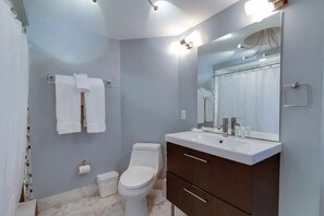 Ein Badezimmer mit Toilette, Waschbecken, Spiegel und Handtuchhalter.