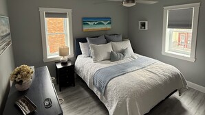A bedroom with a bed, nightstands, a ceiling fan, and a window with a view. - Executive Guest 45N (North Glengarry)