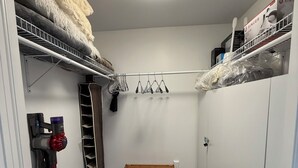 A compact storage room with a ceiling light, a vacuum cleaner, a drying rack, and a clothes rack. - Executive Guest 45N (North Glengarry)