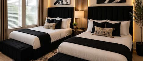 A hotel room with two beds, a large window with blinds, a floor lamp, and abstract wall art.