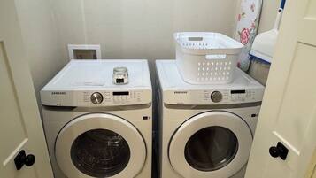 Deux machines à laver Samsung dans une buanderie, avec un panier blanc posé sur l’une d’elles.