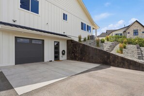 A two-story house with a garage, a front door, and a small front yard with a concrete driveway. - Peaceful|Hot Tub|Sauna|Close to Downtown (Castle Rock)