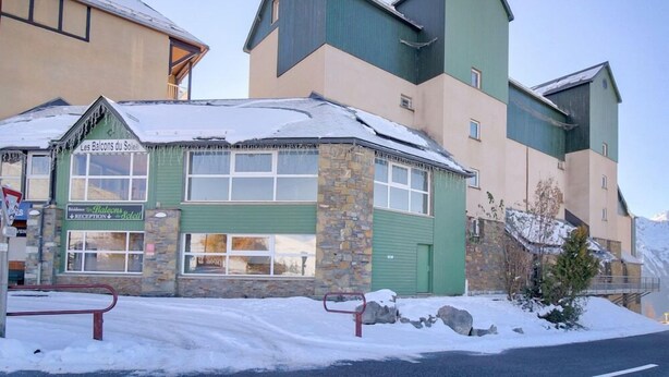 Un bâtiment doté d’un hall d’accueil, d’une façade en pierre et d’une porte verte.