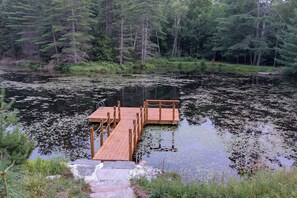 A wooden dock extending into a pond surrounded by dense forest. - Cabin with Private Pond - 61 Acres - Close to Gore (Johnsburg)