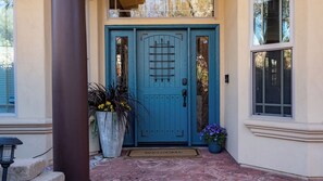 A blue door with a metal gate, a welcome mat, and potted plants. - Hilltop Hacienda by Avantstay Game Room + Hot Tub Hilltop Paso Views (Paso Robles)