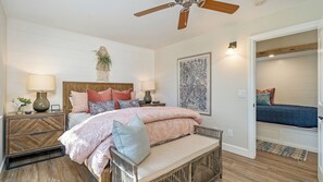 A bedroom with a bed, bedside tables, a ceiling fan, a wall-mounted plant, and a framed artwork. - Hilltop Hacienda by Avantstay Game Room + Hot Tub Hilltop Paso Views (Paso Robles)