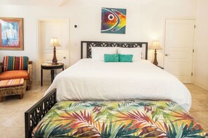 Ein Hotelzimmer mit einem Bett, zwei Nachttischen, einem Sessel und einem Bild an der Wand.