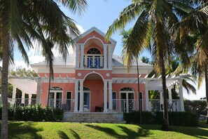A two-story building with a pink facade, white trim, and a central balcony. - Paradise Villa - 3BR / 3BA w/ Boat Slip in February Point (George Town)