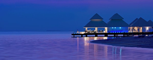 A waterfront resort with overwater bungalows and a pier.