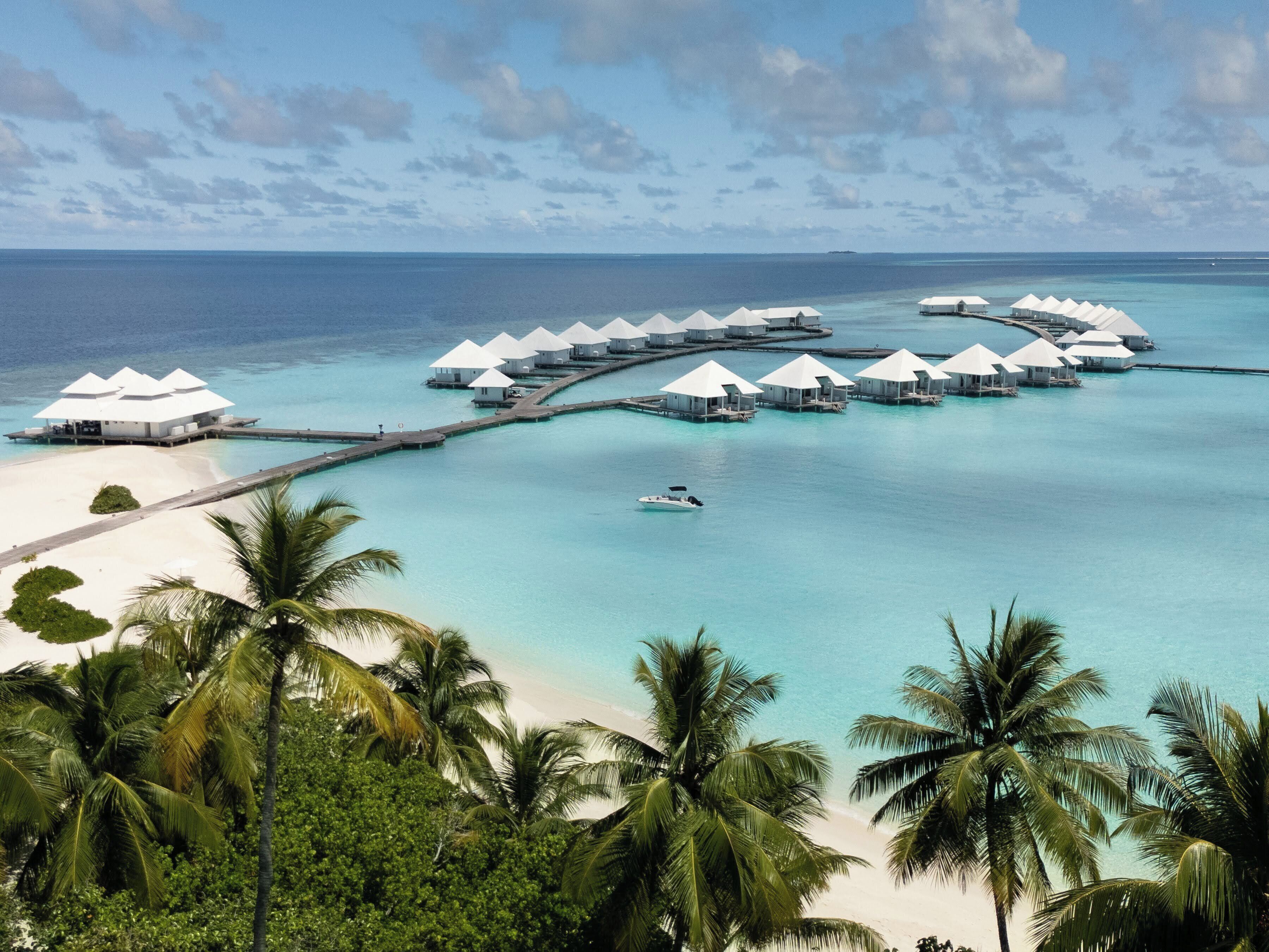 Un resort sobre el agua con múltiples alojamientos tipo bungalow conectados por pasarelas.