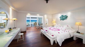A hotel room with a bed, a desk, a chair, and a view of the sea. - Diamonds Athuruga Maldives Resort and SPA (Athuruga Island)