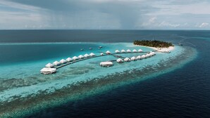 An overwater bungalow resort with multiple structures connected by walkways over clear turquoise waters. - Diamonds Athuruga Maldives Resort and SPA (Athuruga Island)
