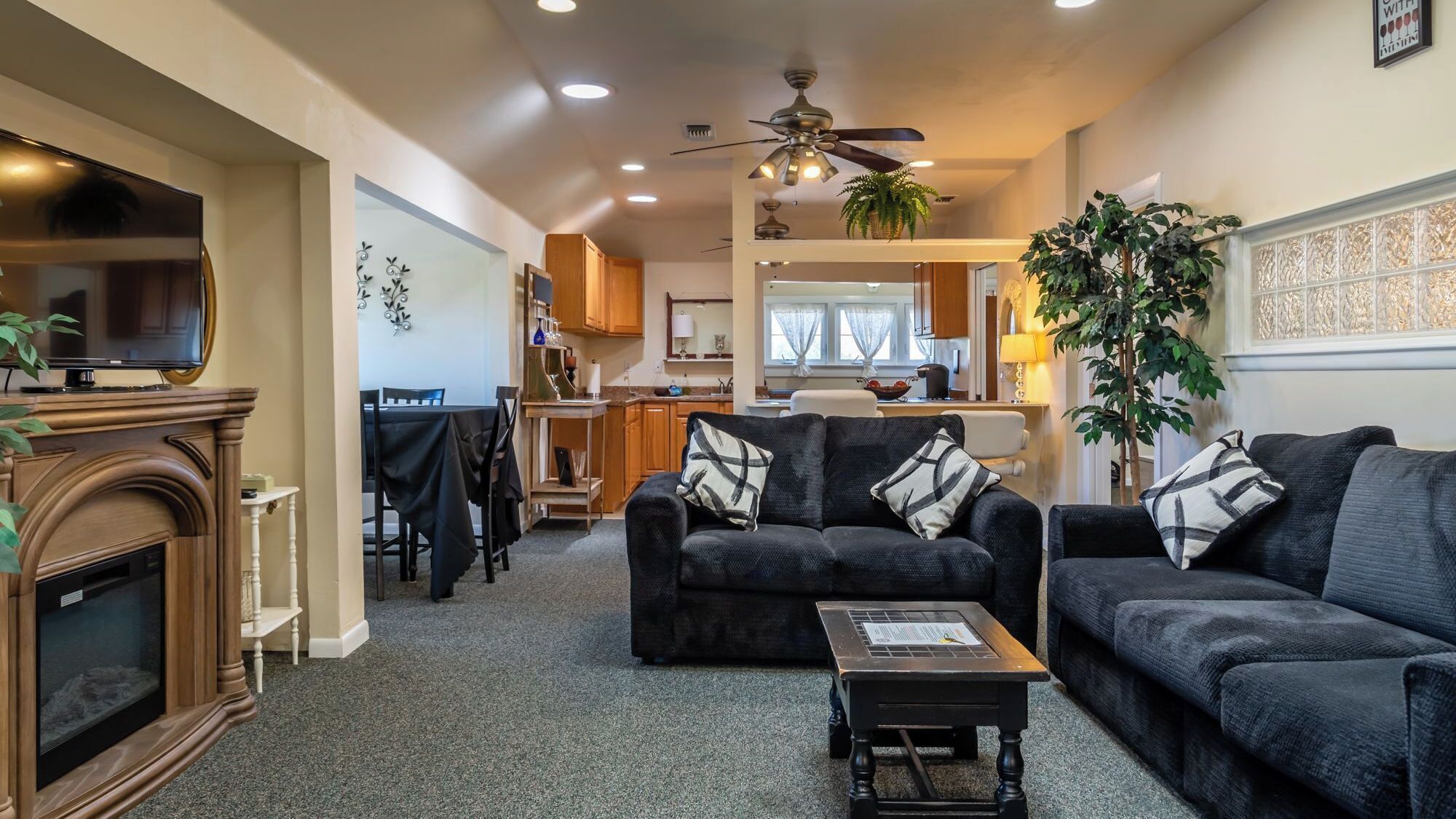 A living room with a fireplace, two sofas, a coffee table, and a television.