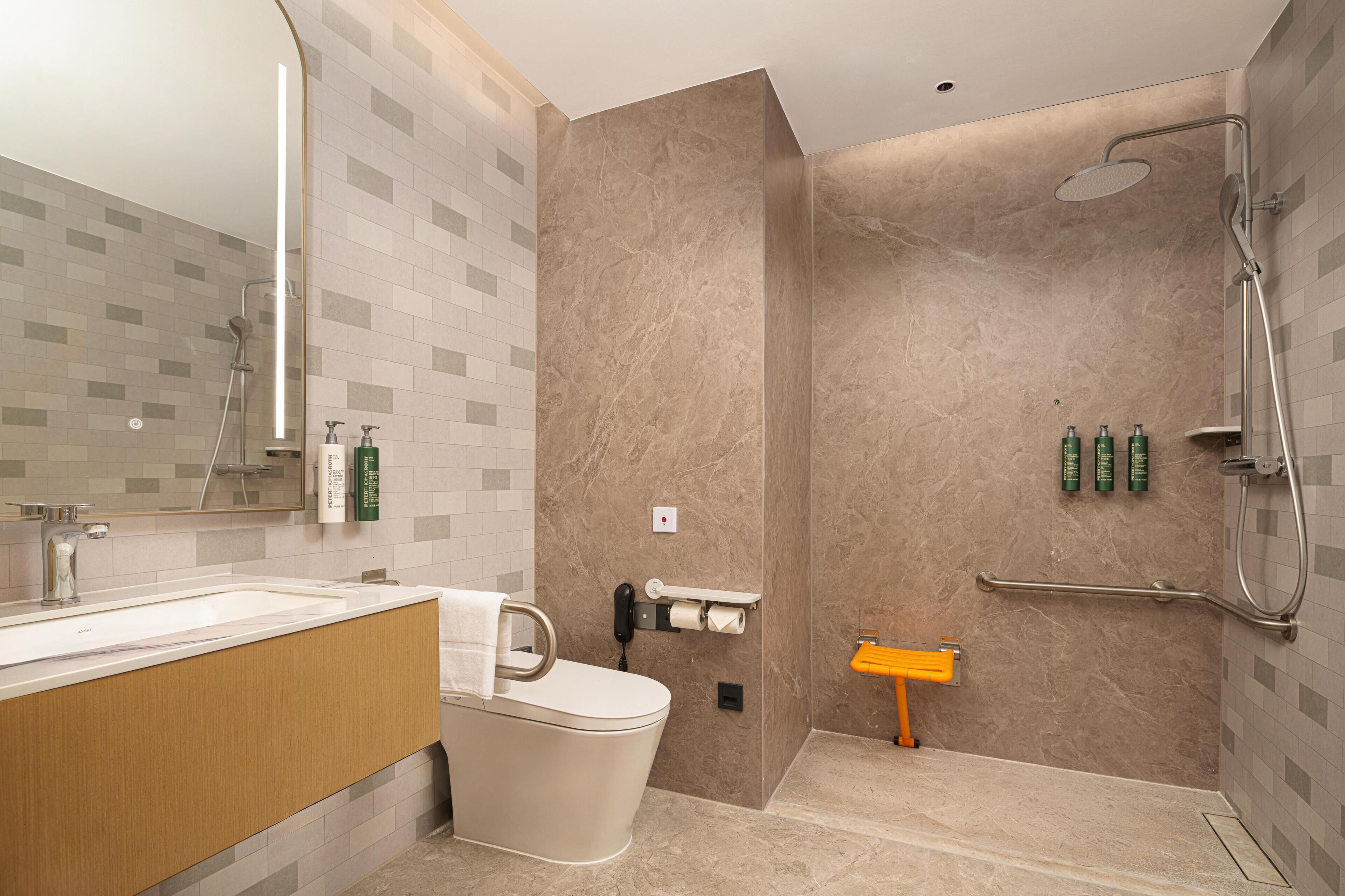 A modern bathroom with a toilet, sink, and shower area.