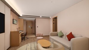 En moderne stue med sofa, et lille rundt bord, et skrivebord og en stol.