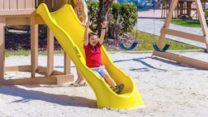 Ein Spielplatz mit Rutsche und Schaukeln.