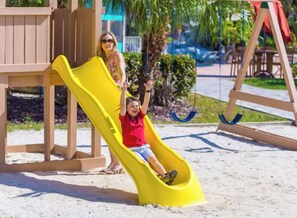 A playground with a yellow slide and a swing set. - Cozy 1-bedroom apartment with AC in welcoming Freeport (Freeport)