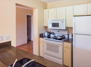 A kitchen with a microwave, stove, and refrigerator. - Cozy 1-bedroom apartment with AC in welcoming Freeport (Freeport)