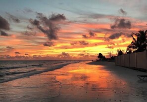 A beach at sunset with a calm sea, a clear sky, and a fence along the shore. - Cozy 1-bedroom apartment with AC in welcoming Freeport (Freeport)