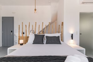 Habitación de hotel moderna con una cama grande, un cabecero de madera y vistas de la escalera.