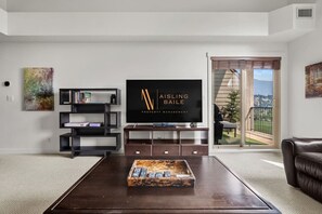 Ein modernes Wohnzimmer mit Flachbildfernseher, Couchtisch und Ledersofa.