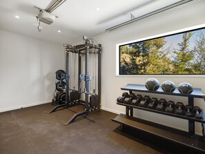 Ein Fitnessstudio mit Krafttrainingsgeräten und Kurzhanteln.